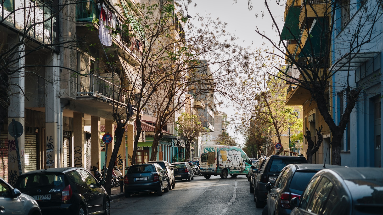 Calle urbana con coches aparcados a ambos lados